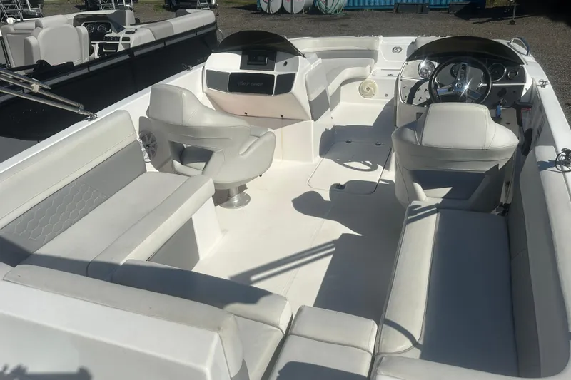 Slide: The Image of 2022 Hurricane Sundeck Sport 218 OB boat interior with white seating and steering console. - 6