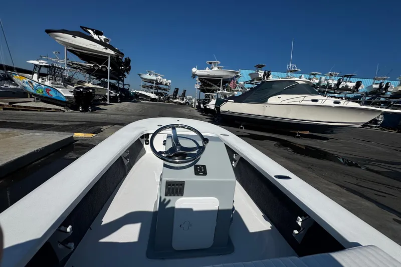 Slide: The Image of 2026 Mitzi Skiffs 17 Tournament boat at marina, surrounded by various docked boats. - 11