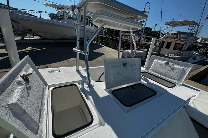Slide: The Image of 2026 Mitzi Skiffs 17 Tournament boat with open storage compartments at a marina. - 13