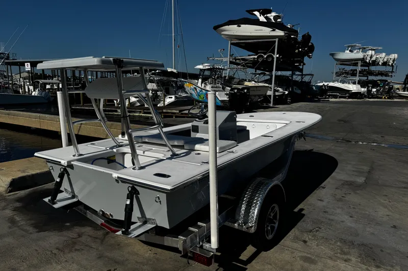 Slide: The Image of 2026 Mitzi Skiffs 17 Tournament boat on trailer at marina, surrounded by other boats. - 6