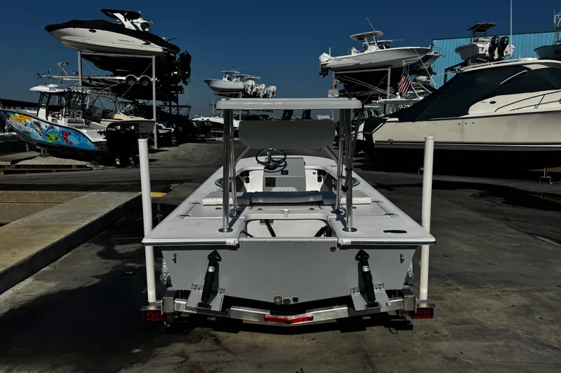 Slide: The Image of 2026 Mitzi Skiffs 17 Tournament boat on trailer at marina, surrounded by other boats. - 7