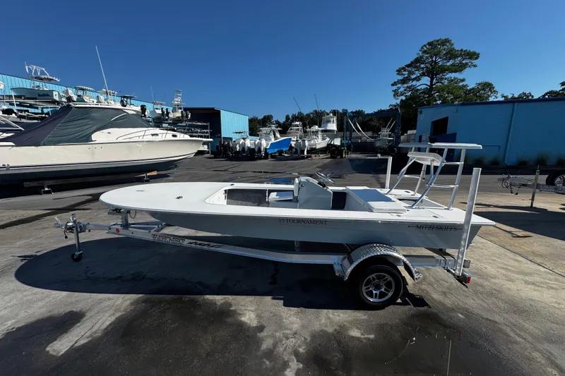Slide: The Image of 2026 Mitzi Skiffs 17 Tournament boat on trailer in marina setting. - 9