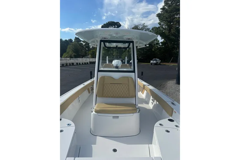 Slide: The Image of 2025 Sportsman Masters 267 Bay Boat interior with tan seating and T-top under blue sky. - 11