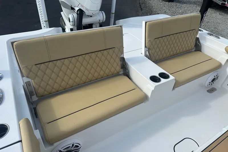 Slide: The Image of 2025 Sportsman Masters 267 Bay Boat with beige cushioned seating and cup holders. - 16