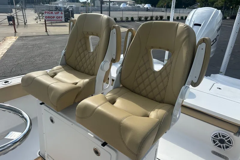 Slide: The Image of 2025 Sportsman Masters 267 Bay Boat with tan leather seats, docked outdoors. - 4