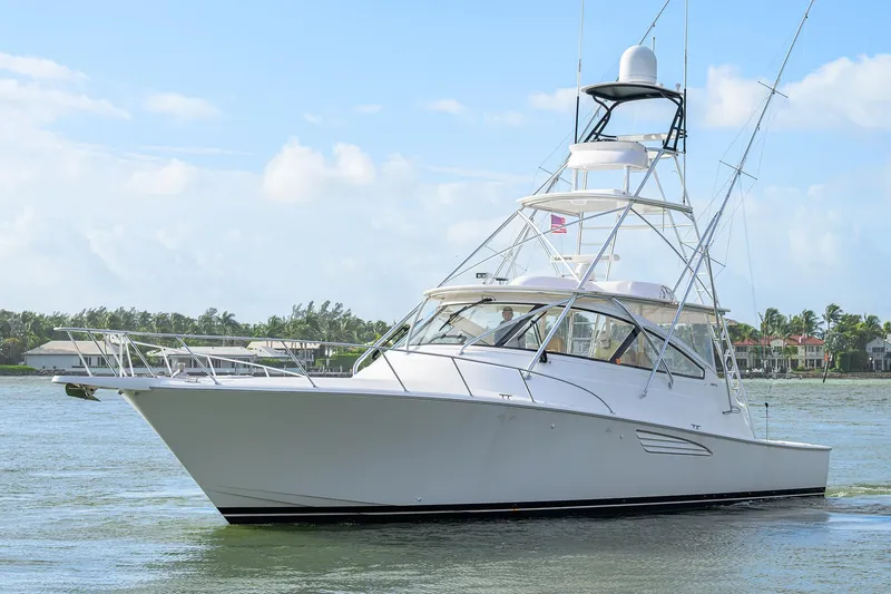 The Image of 2015 Viking 52 Open yacht cruising on a sunny day near coastal homes. - 0