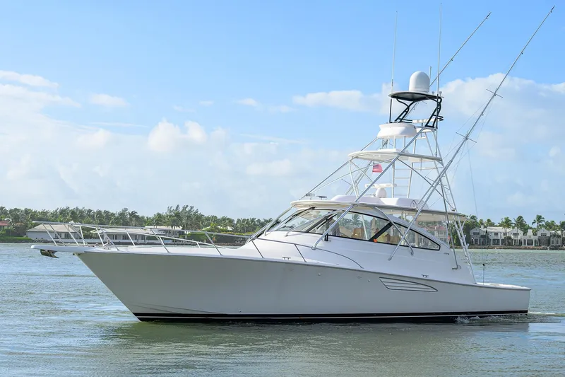 Slide: The Image of 2015 Viking 52 Open yacht cruising on calm waters under a clear blue sky. - 13