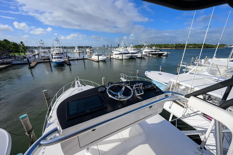 Slide: The Image of Helm view from 2015 Viking 52 Open yacht at marina with boats and blue sky. - 14