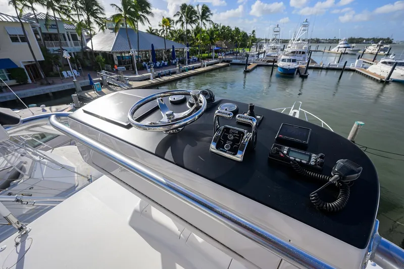 Slide: The Image of Helm of 2015 Viking 52 Open yacht at marina with palm trees and boats. - 17