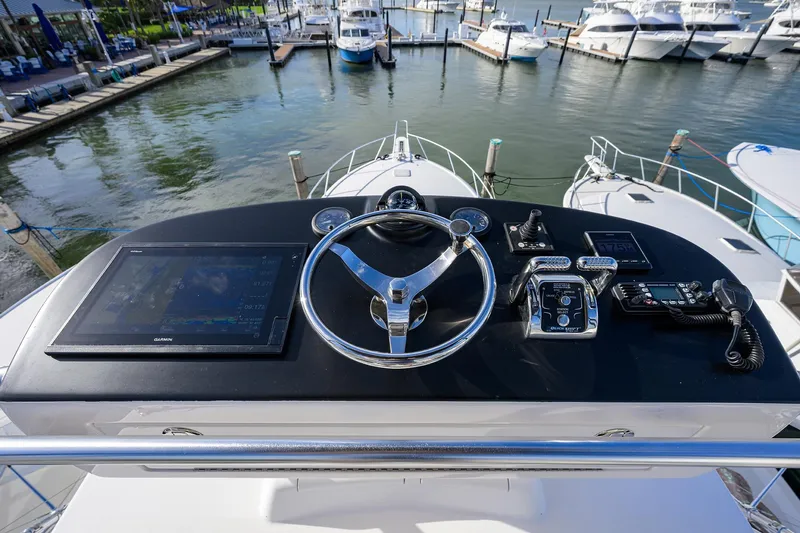 Slide: The Image of Helm of 2015 Viking 52 Open yacht with navigation controls and marina view. - 18