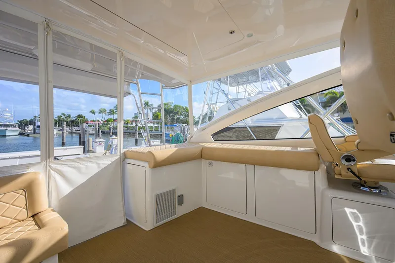 Slide: The Image of Interior view of 2015 Viking 52 Open yacht with beige seating and marina backdrop. - 26
