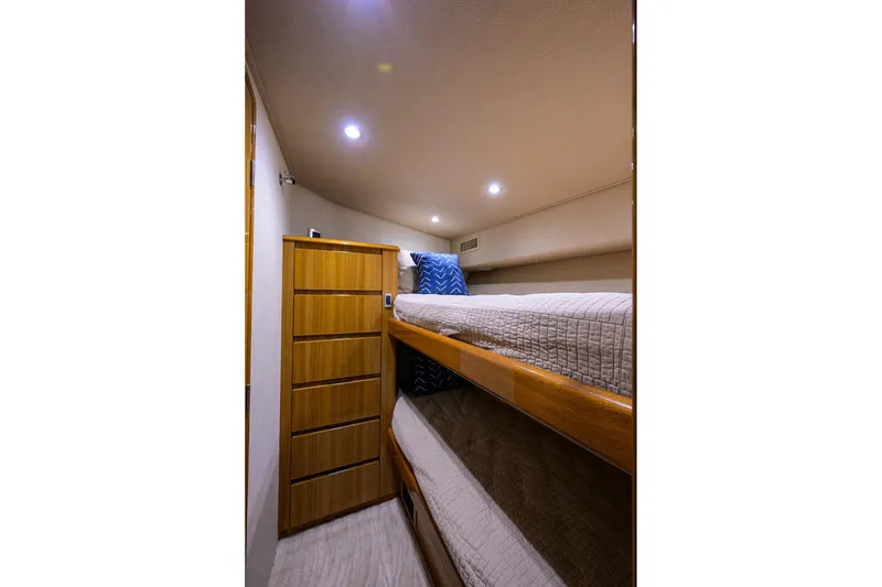 Slide: The Image of 2015 Viking 52 Open yacht cabin with bunk beds and wooden storage. - 65