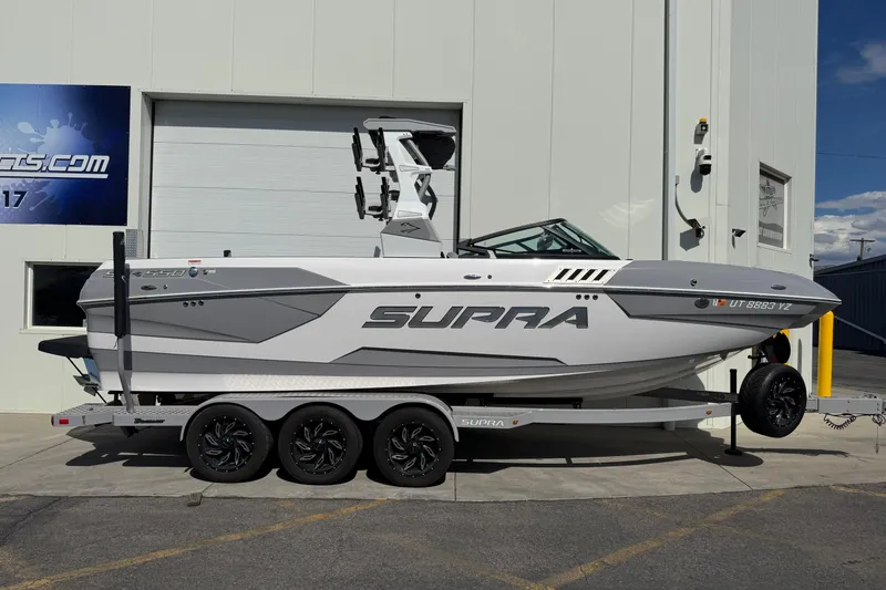 The Image of 2019 Supra SE 575 boat on trailer, parked outside a building. - 1