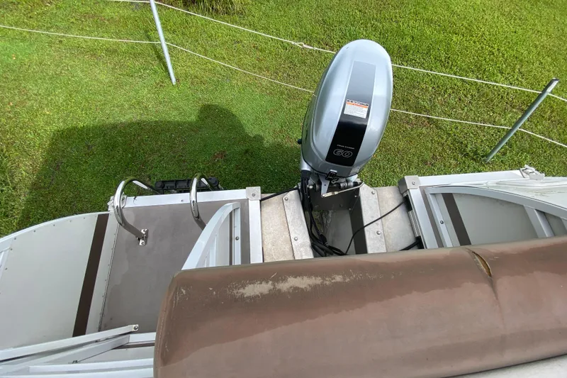 Slide: The Image of 2010 JC NEPTOON 19 boat with outboard motor, viewed from above on grass. - 13