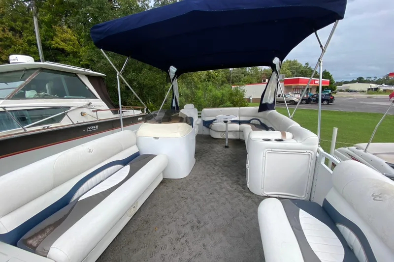 Slide: The Image of 2010 JC NEPTOON 19 pontoon boat with spacious seating and canopy, docked beside another boat. - 9