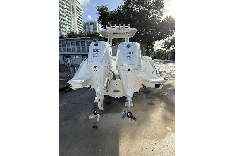 Slide: The Image of 2025 Pursuit S 288 Sport boat with dual 300 V6 engines, docked outdoors. - 2