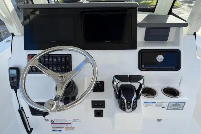 Slide: The Image of 2025 Pursuit S 288 Sport boat dashboard with steering wheel, controls, and dual screens. - 3
