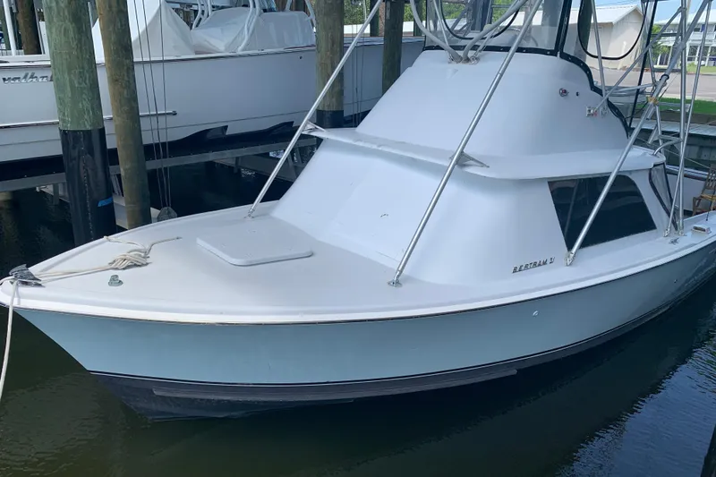 Slide: The Image of 1974 Bertram 31 Flybridge Cruiser docked, showcasing classic design and sleek lines. - 0