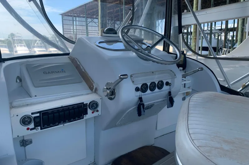 Slide: The Image of 1974 Bertram 31 Flybridge Cruiser helm with Garmin navigation system and classic controls. - 12