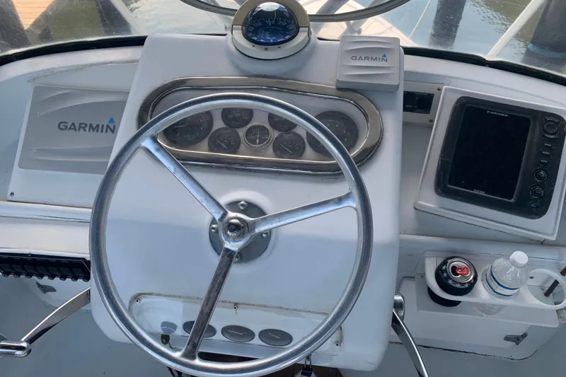 Slide: The Image of 1974 Bertram 31 Flybridge Cruiser helm with Garmin navigation and steering wheel. - 14