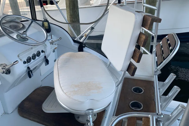 Slide: The Image of 1974 Bertram 31 Flybridge Cruiser helm with steering wheel and seating. - 16