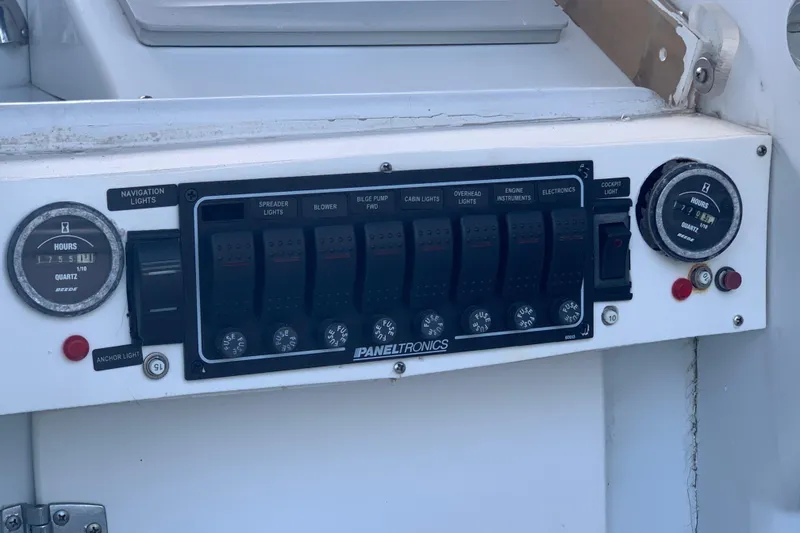 Slide: The Image of Control panel of a 1974 Bertram 31 Flybridge Cruiser with various switches and gauges. - 18