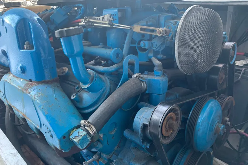 Slide: The Image of Engine of a 1974 Bertram 31 Flybridge Cruiser, showcasing blue components and belts. - 29