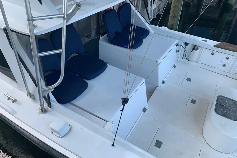 Slide: The Image of 1974 Bertram 31 Flybridge Cruiser with blue cushioned seating and spacious deck area. - 3