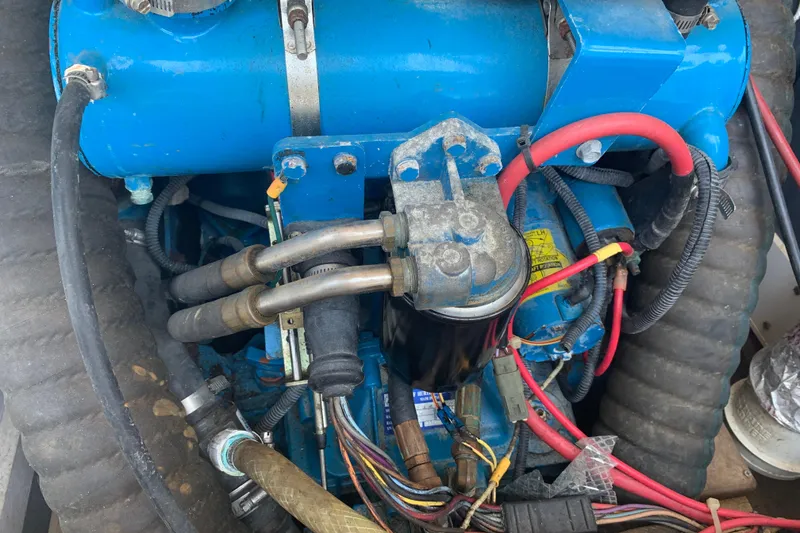 Slide: The Image of Engine components of a 1974 Bertram 31 Flybridge Cruiser, featuring blue and red wiring. - 42