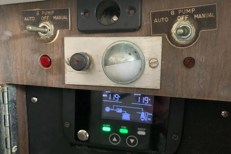 Slide: The Image of Control panel of a 1974 Bertram 31 Flybridge Cruiser with pump switches and digital display. - 47