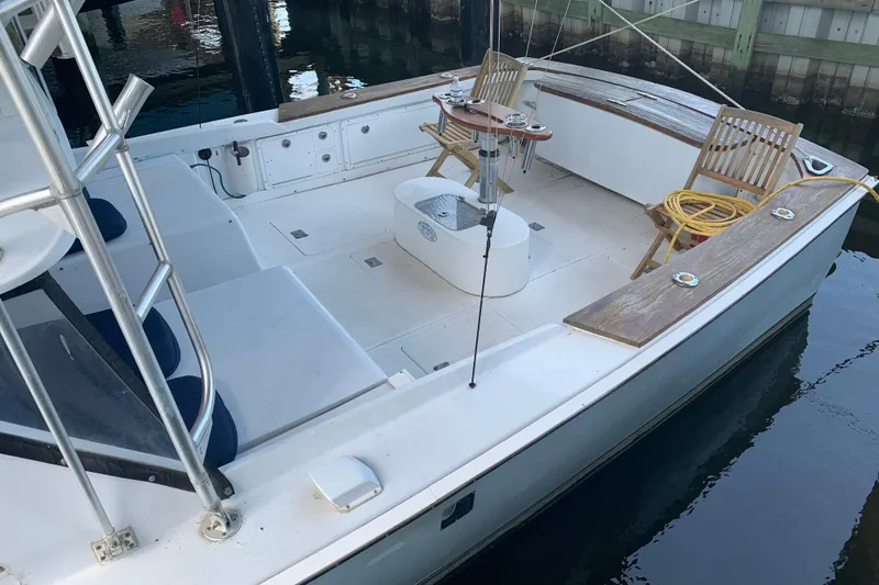 Slide: The Image of 1974 Bertram 31 Flybridge Cruiser with spacious deck and seating, docked at marina. - 6