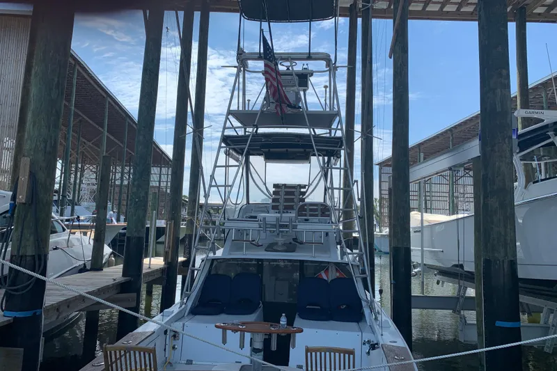 Slide: The Image of 1974 Bertram 31 Flybridge Cruiser docked in a marina, rear view. - 8