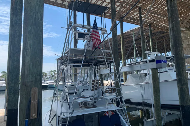 Slide: The Image of 1974 Bertram 31 Flybridge Cruiser docked under a wooden canopy. - 9