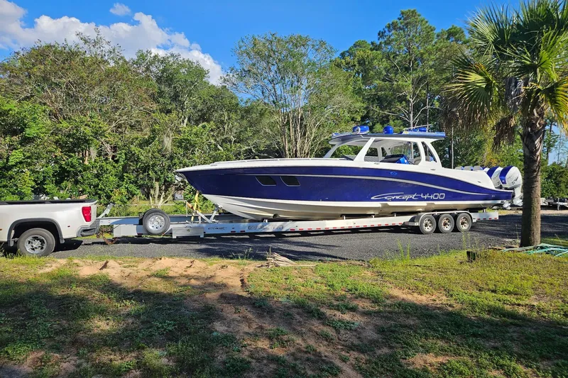 The Image of 2019 Concept 44' Cuddy Cabin boat on trailer, surrounded by lush greenery. - 9