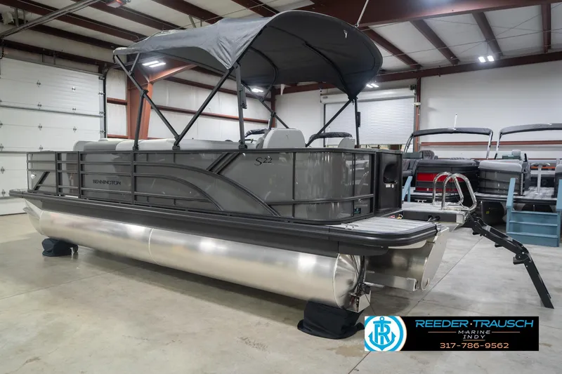 Slide: The Image of 2026 Bennington 22 SF pontoon boat in showroom with canopy and trailer. - 10