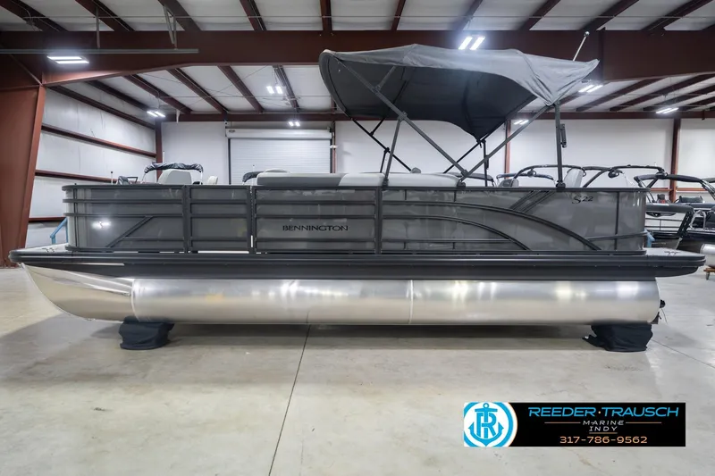 Slide: The Image of 2026 Bennington 22 SF pontoon boat in a showroom with canopy and sleek design. - 11