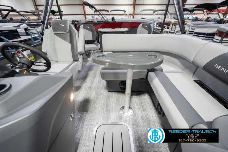Slide: The Image of 2026 Bennington 22 SF boat interior with gray seating and table, showcased at Reeder Trausch Marine. - 17