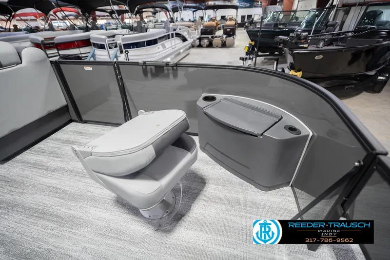 Slide: The Image of 2026 Bennington 22 SF boat interior with seating and storage, displayed at Reeder-Trausch Marine showroom. - 23