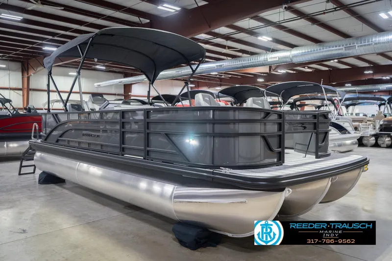 Slide: The Image of 2026 Bennington 22 SF pontoon boat in showroom, featuring sleek design and canopy. - 6