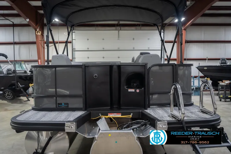 Slide: The Image of 2026 Bennington 22 SF pontoon boat in showroom, featuring sleek design and dual ladders. - 9