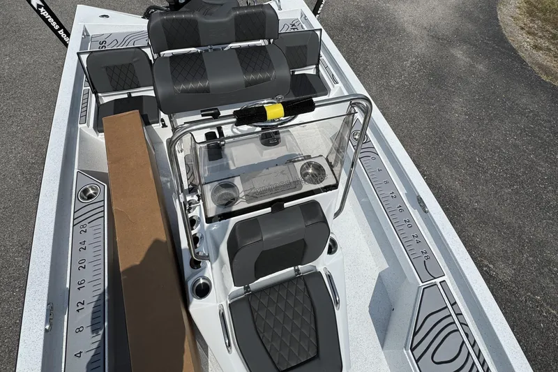 Slide: The Image of 2026 Xpress H20B Bay boat interior with seating, console, and measuring ruler on deck. - 6