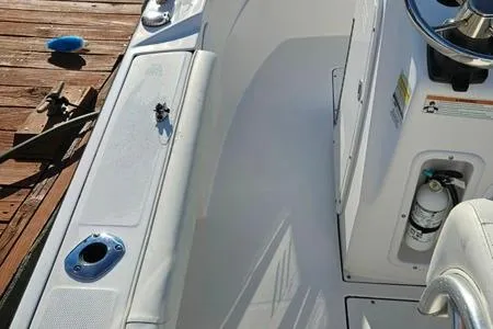 Slide: The Image of 2021 Edgewater 188CC boat interior with seating and control panel, docked on wooden pier. - 13