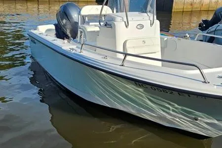 Slide: The Image of 2021 Edgewater 188CC boat docked on calm water, featuring sleek design and outboard motor. - 23