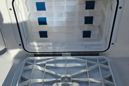 Slide: The Image of Open storage compartment on 2021 Edgewater 188CC boat, featuring organized tackle boxes. - 24