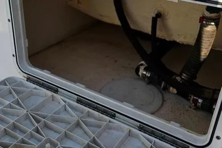 Slide: The Image of 2021 Edgewater 188CC boat storage compartment with visible hoses and fittings. - 25