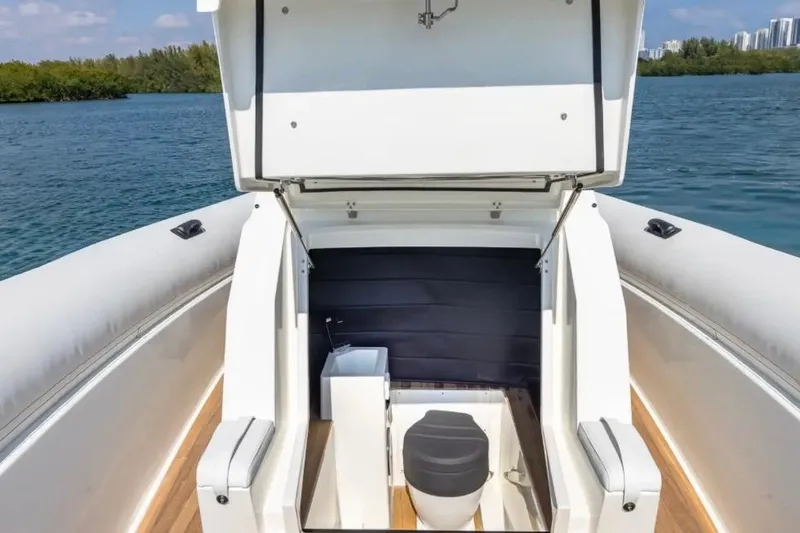 Slide: The Image of 2025 Technohull GTX boat with open storage compartment, featuring a toilet and sink. - 17