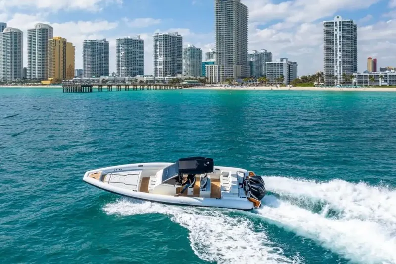 Slide: The Image of 2025 Technohull GTX boat cruising near city skyline and beach. - 20