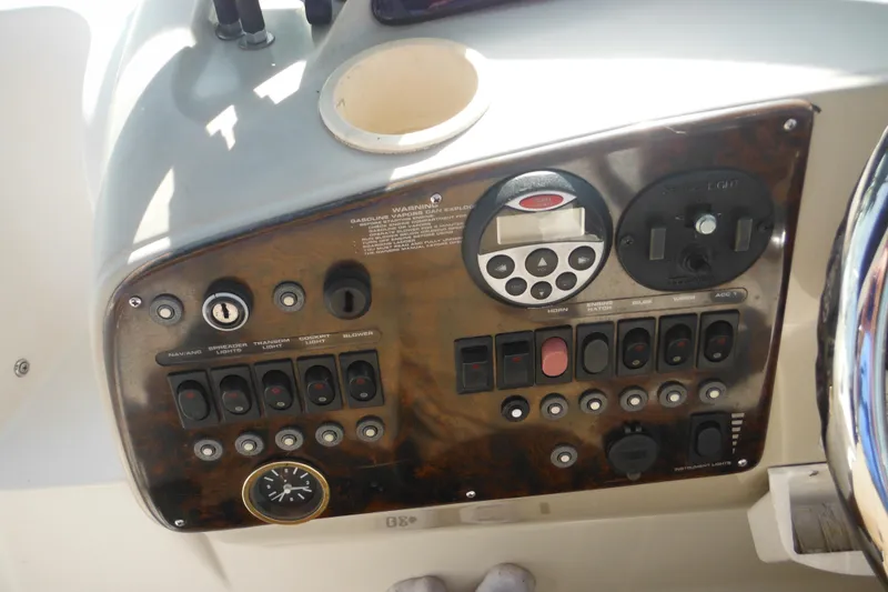 Slide: The Image of Control panel of a 2000 Rinker 330 Fiesta Vee boat with various switches and dials. - 18