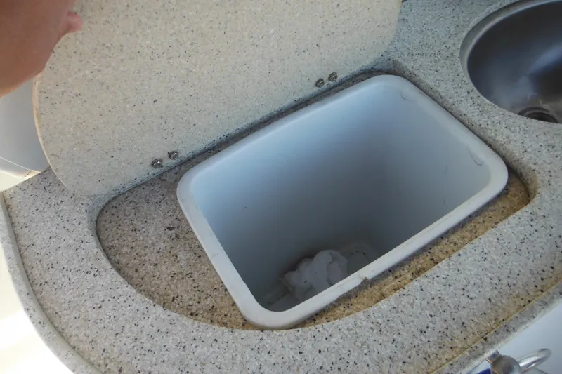 Slide: The Image of Open storage compartment on 2000 Rinker 330 Fiesta Vee boat, featuring a speckled countertop. - 29