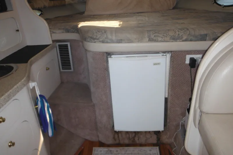 Slide: The Image of Interior of 2000 Rinker 330 Fiesta Vee boat with compact kitchen and bed. - 41